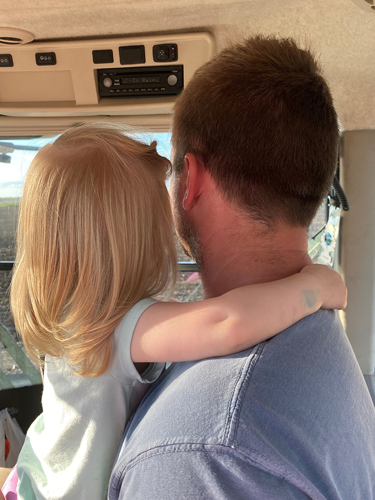 Kara's husband and daughter in the tractor cab