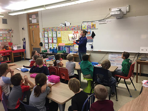 Carie reads to students about ag