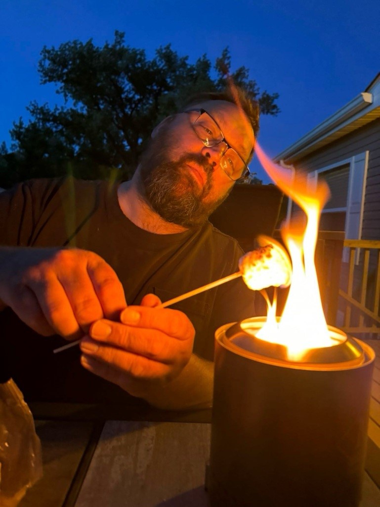 roasting a marshmallow over a small flame